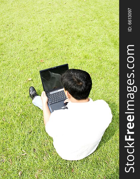 A young man using a laptop outdoors