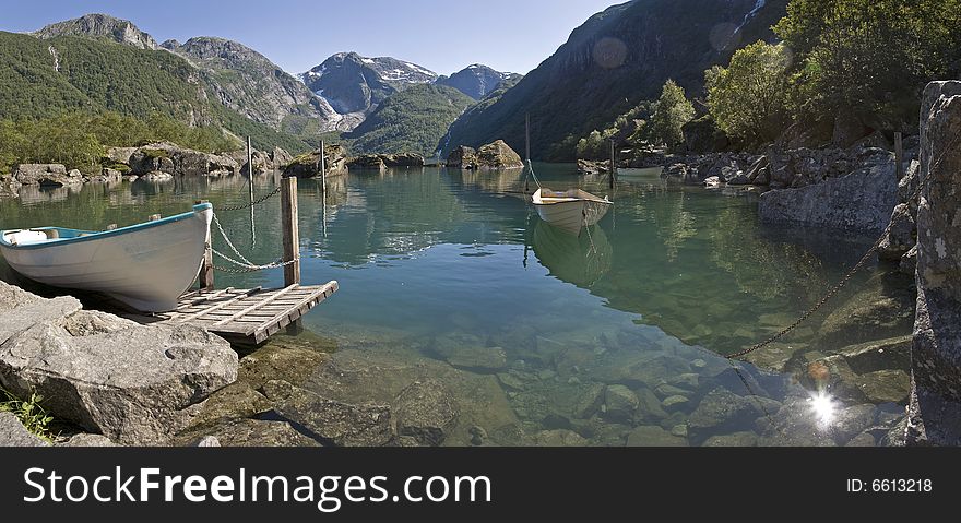 A boat on the Bondhusvatnet lake, Folgefonn, Norway. The Folgefonn glacier with the Bondhusbreen ice-fall in behind. A boat on the Bondhusvatnet lake, Folgefonn, Norway. The Folgefonn glacier with the Bondhusbreen ice-fall in behind.