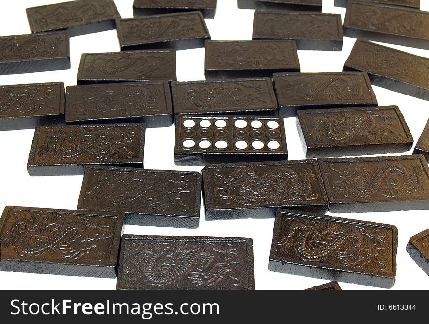 Photograph of black dominoes, face down, with one six-six face up. Isolated on white background. Photograph of black dominoes, face down, with one six-six face up. Isolated on white background.