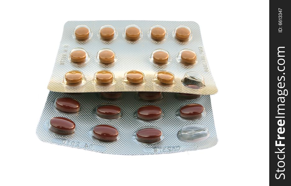 Close up photograph of 2 foil strips with tablets, some missing, isolated on white background. Close up photograph of 2 foil strips with tablets, some missing, isolated on white background.