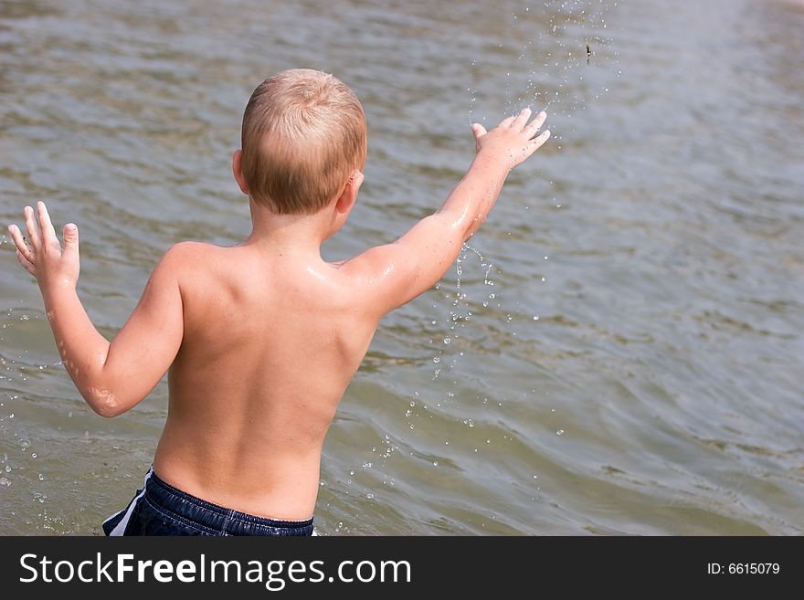 Boy throwing sand in the water. Boy throwing sand in the water