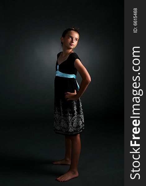 Studio portrait of aloof, confident looking young pretty girl in black dress. Studio portrait of aloof, confident looking young pretty girl in black dress