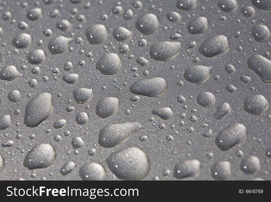 Rain drops on metallic surface closeup