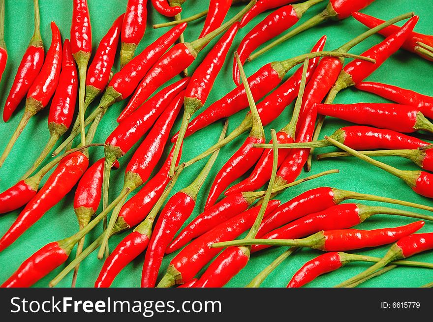 Red chili peppers on green background