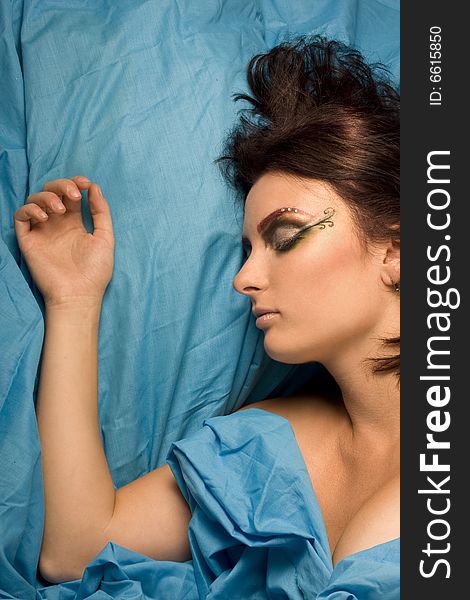 Woman sleeping blue studio lighting makeup eyes closed dreams bedclothes. Woman sleeping blue studio lighting makeup eyes closed dreams bedclothes