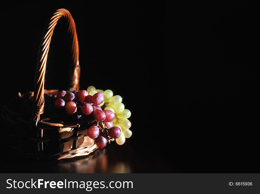 A wooden basket filled with grapes. A wooden basket filled with grapes