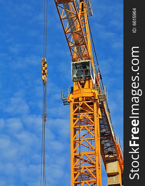 Yellow construction crane aginst blue sky