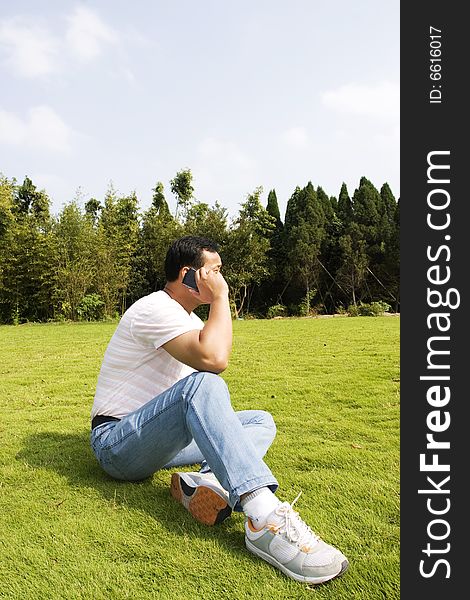 The man using cell phone outdoors.