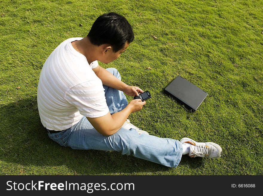 The man using cell phone outdoors.