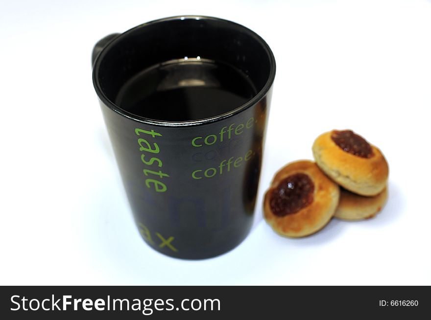 A black hot cup of cafe, with some cokies. A black hot cup of cafe, with some cokies