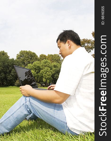 A young man using a laptop outdoors