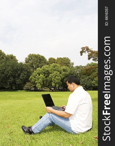A young man using a laptop outdoors