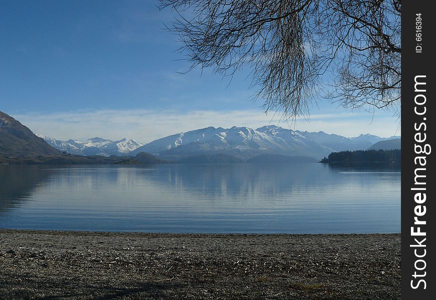 A calm lake surrounded by snowy mountains. A calm lake surrounded by snowy mountains.