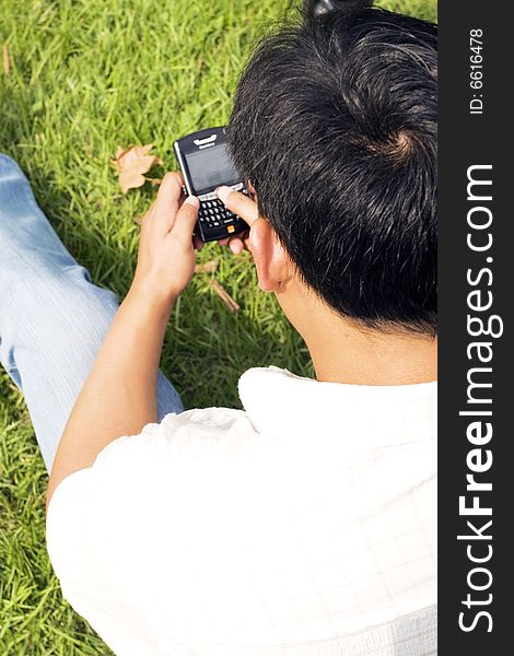 The man using cell phone outdoors.