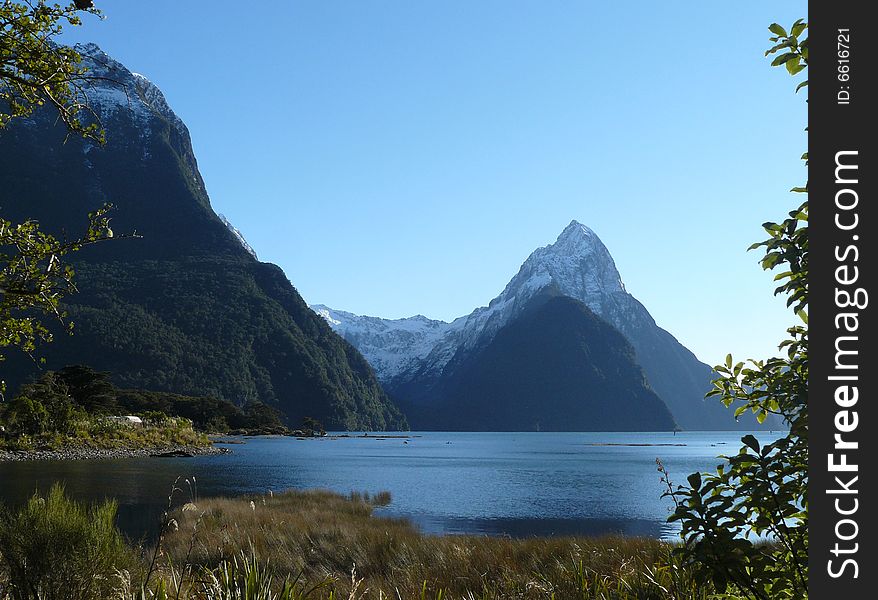 The lake at Milford Sound, New Zealand with the snow capped mountain Mitre Peak in the background,. The lake at Milford Sound, New Zealand with the snow capped mountain Mitre Peak in the background,