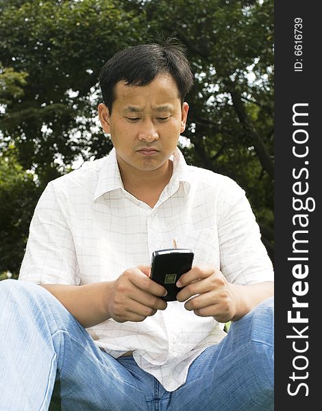 The man using cell phone outdoors.