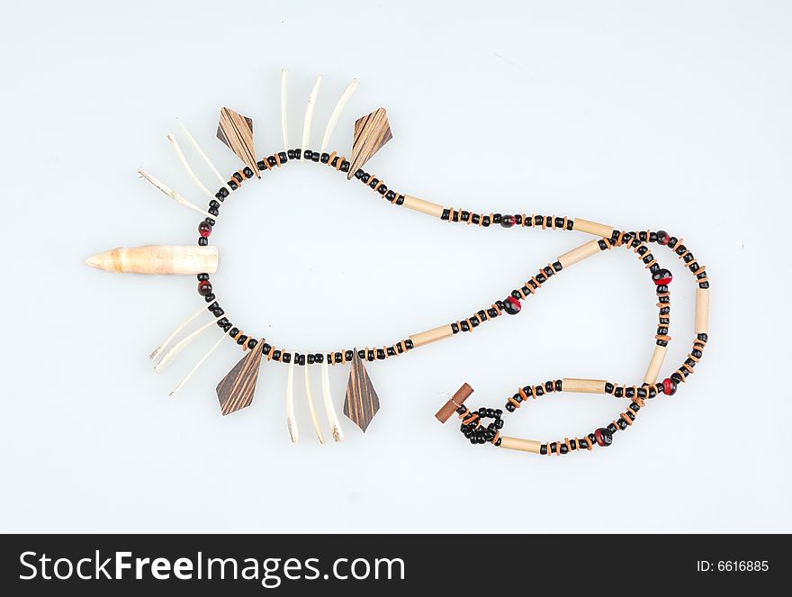 Indian necklace with wooden and crocodilian tooth on white