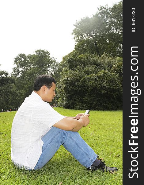 The man using cell phone outdoors.