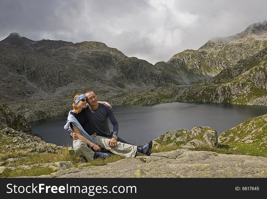 A couple relaxing at lake in Italian mountains. A couple relaxing at lake in Italian mountains