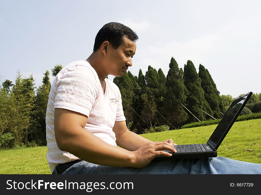 A young man using a laptop outdoors