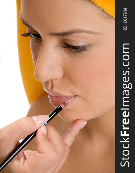 A beautician putting lipstick on woman's lips