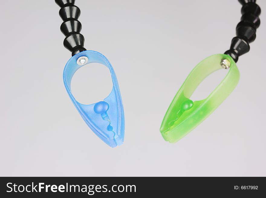 Blue and green plastic clamps on gray