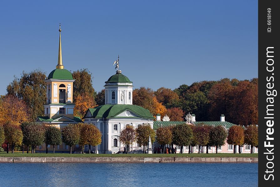 Old steeple on the shore of lake on blue sky background. Old steeple on the shore of lake on blue sky background