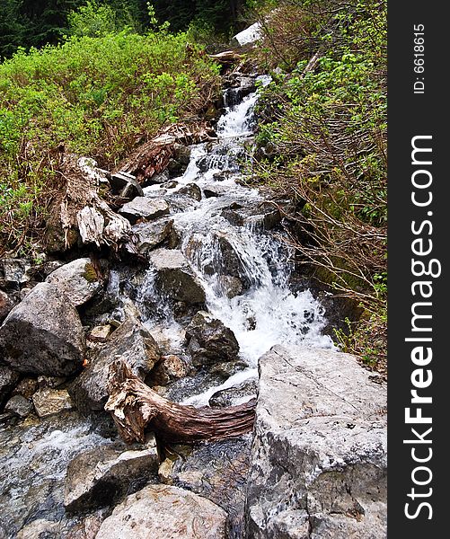 Water flowing down through a river filled with rocks. Water flowing down through a river filled with rocks.