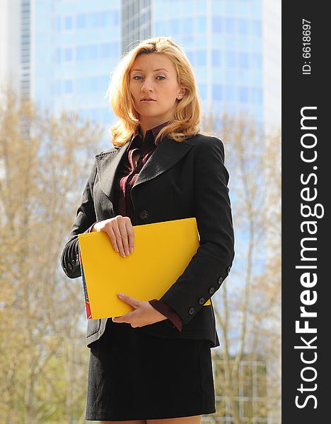 Young business woman holding yellow file. Financial district,Frankfurt,Germany.