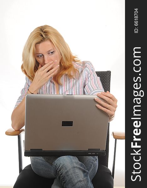 Young woman sitting on a office chair working with her laptop.