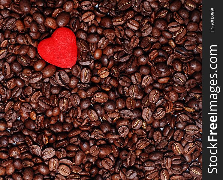 Red heart in the heap of brown coffee seends. Red heart in the heap of brown coffee seends