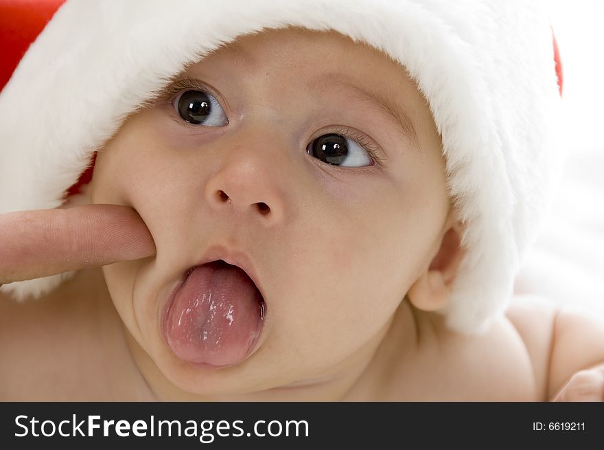 Cute young baby wearing santa cap against white background