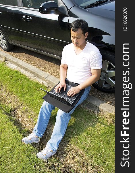 The man working outdoors with a laptop.