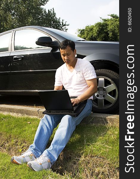 The man working outdoors with a laptop.