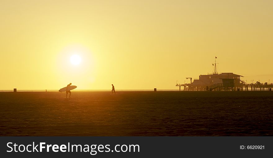 Surfer On Beach At Sunset