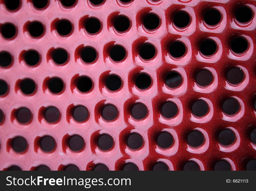 Close-up, abstract, round, holes, vent, venting, background, diagonal, metal, texture, red, ruby. Close-up, abstract, round, holes, vent, venting, background, diagonal, metal, texture, red, ruby