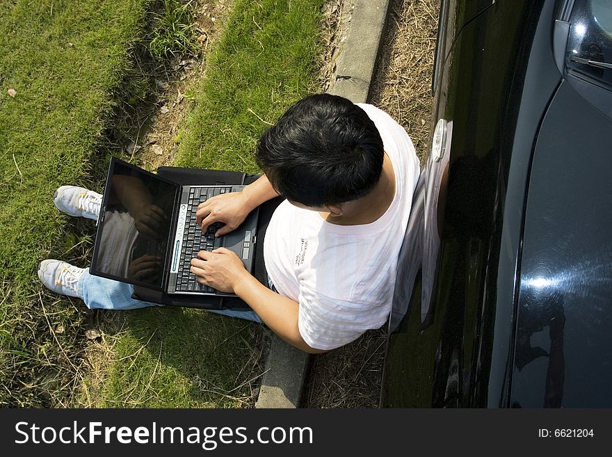 The man working outdoors with a laptop.