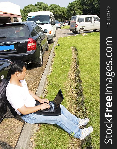 The man working outdoors with a laptop.