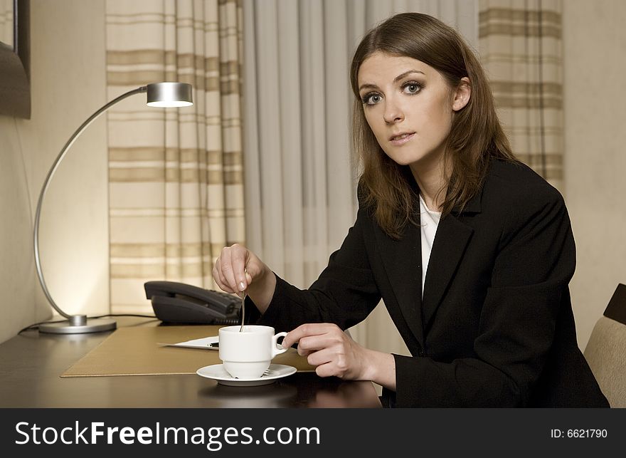 Young businesswoman talking on the phone and working on a laptop in a hotel room