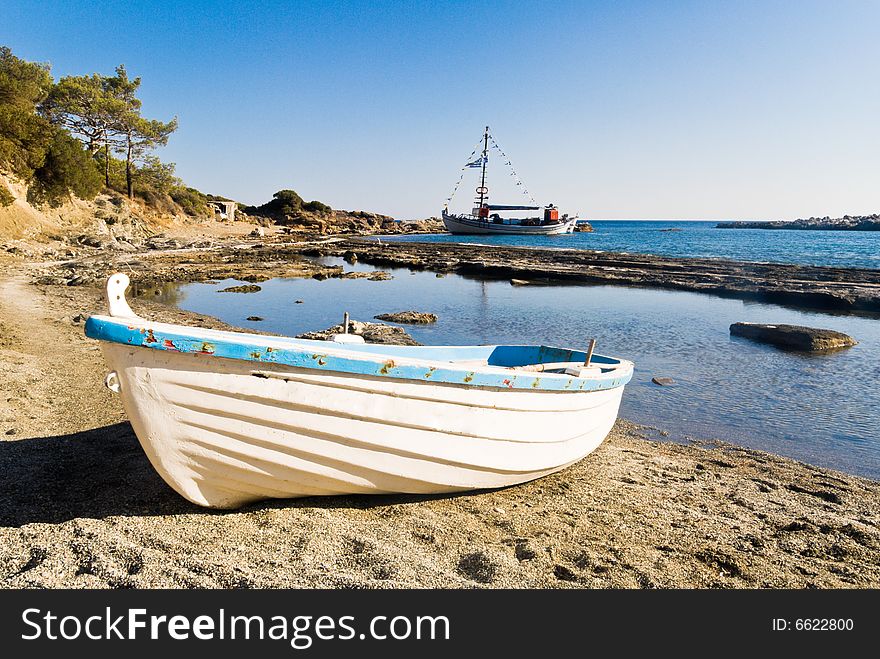 Boat on a sandy beach. A yacht further away. Boat on a sandy beach. A yacht further away.