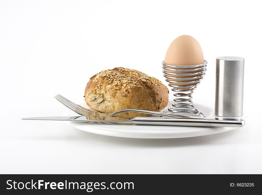 Bun, egg, cutlery and a white plate. Bun, egg, cutlery and a white plate