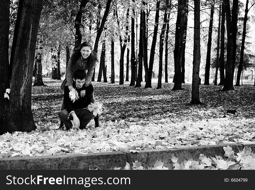 Young beautiful couple have fun In autumn foliage. Young beautiful couple have fun In autumn foliage