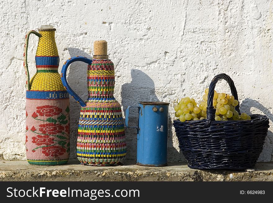Color bottles with basket and white grapes. Color bottles with basket and white grapes