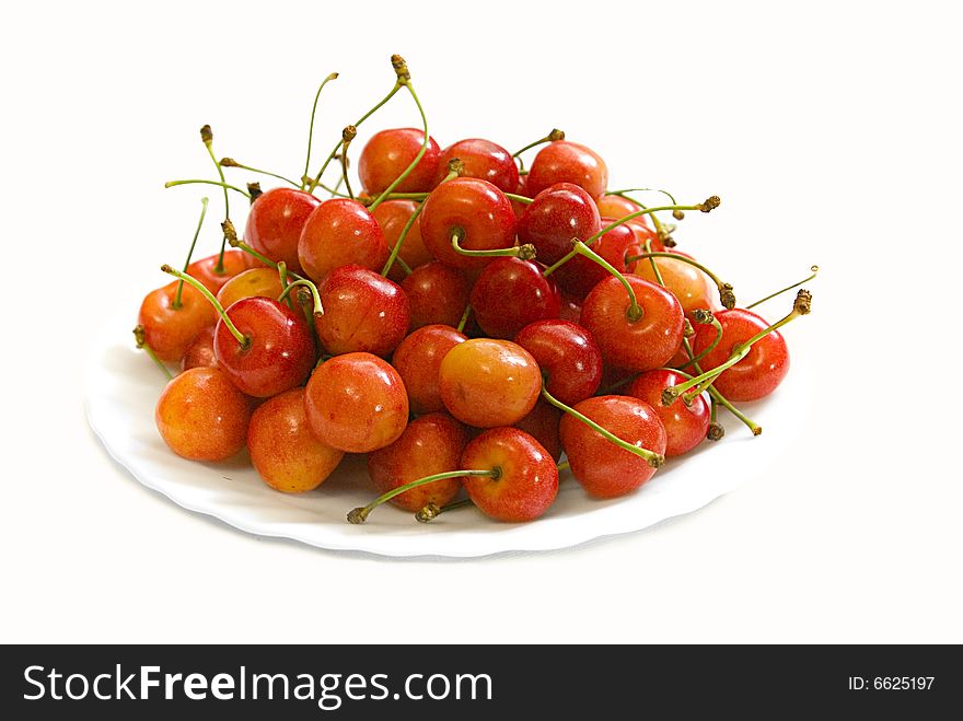 Yellow-red berries a cherries on white dish. Yellow-red berries a cherries on white dish