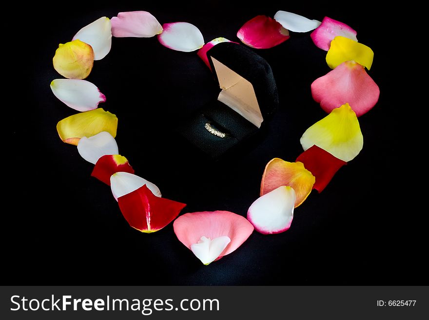 Heart shape made from rose petals and diamond ring. Heart shape made from rose petals and diamond ring
