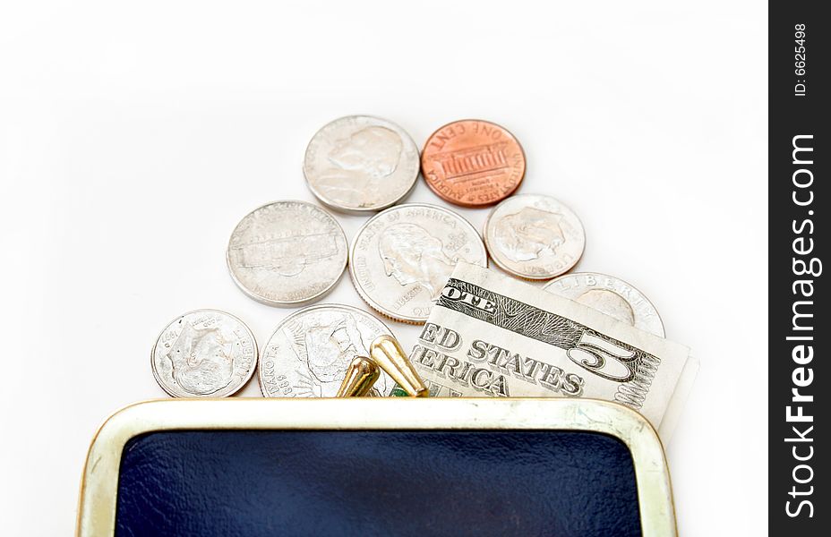 Loose change and a five dollar bill spilling out of a change purse onto an isolated background. Loose change and a five dollar bill spilling out of a change purse onto an isolated background.