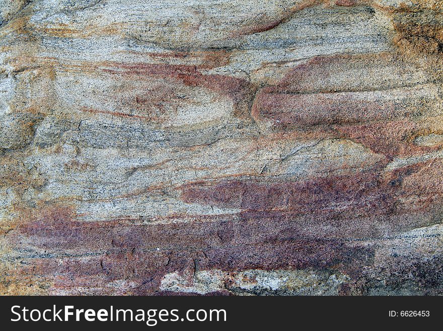 The texture of a red streaked granite rock, perfect for use as a background. The texture of a red streaked granite rock, perfect for use as a background