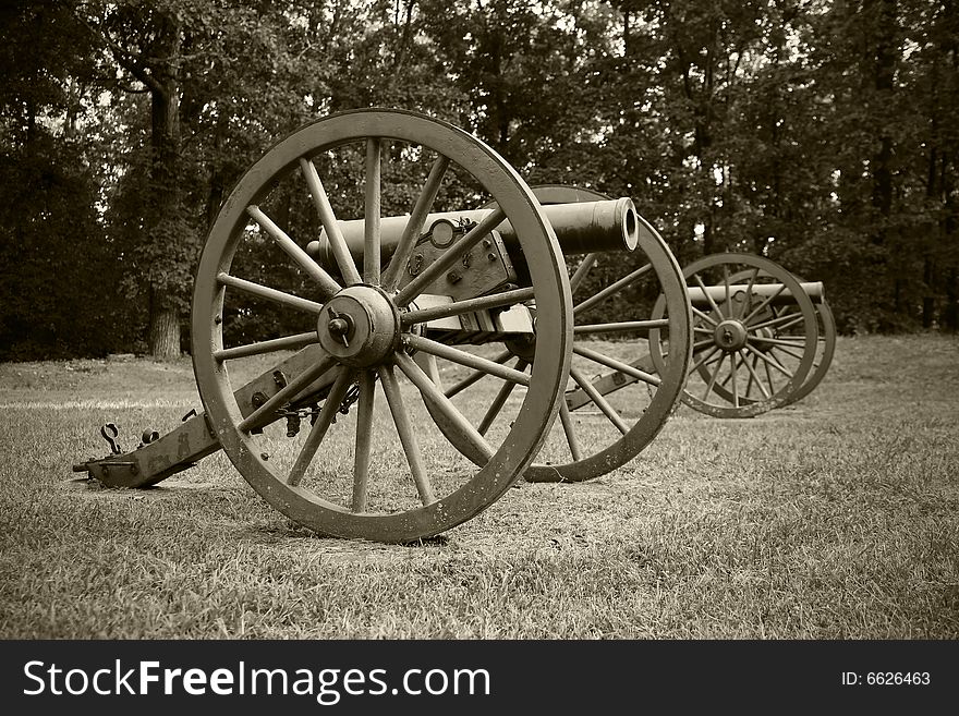 A vintage sepia photograph of old Civil War era canons. A vintage sepia photograph of old Civil War era canons