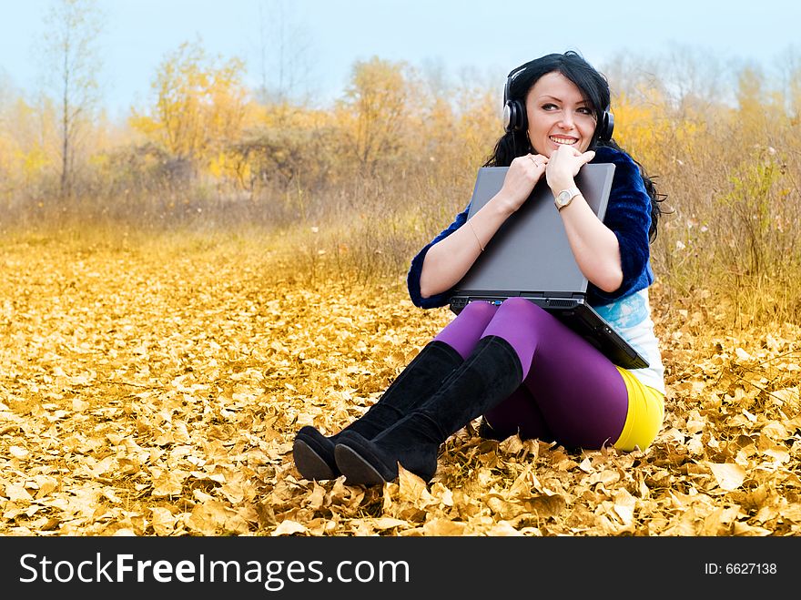 Pretty smiling girl with a laptop in the park. Pretty smiling girl with a laptop in the park