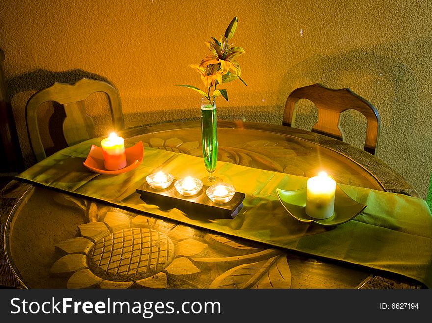 A table with candles and flowers, in an intimate corner of the home. A table with candles and flowers, in an intimate corner of the home